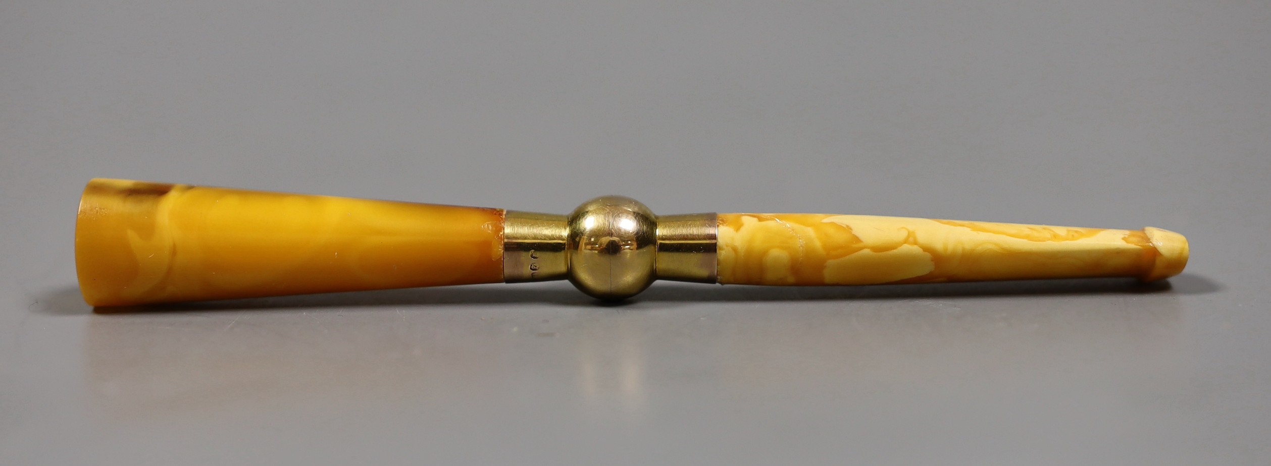 A cased Art Deco 9ct mounted amber cigarette holder
